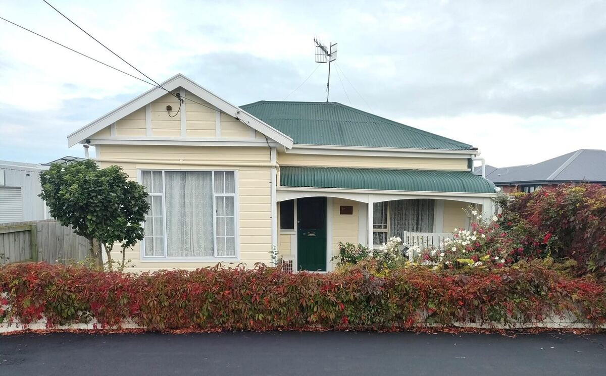Same villa after repaint — heritage cream and green finish