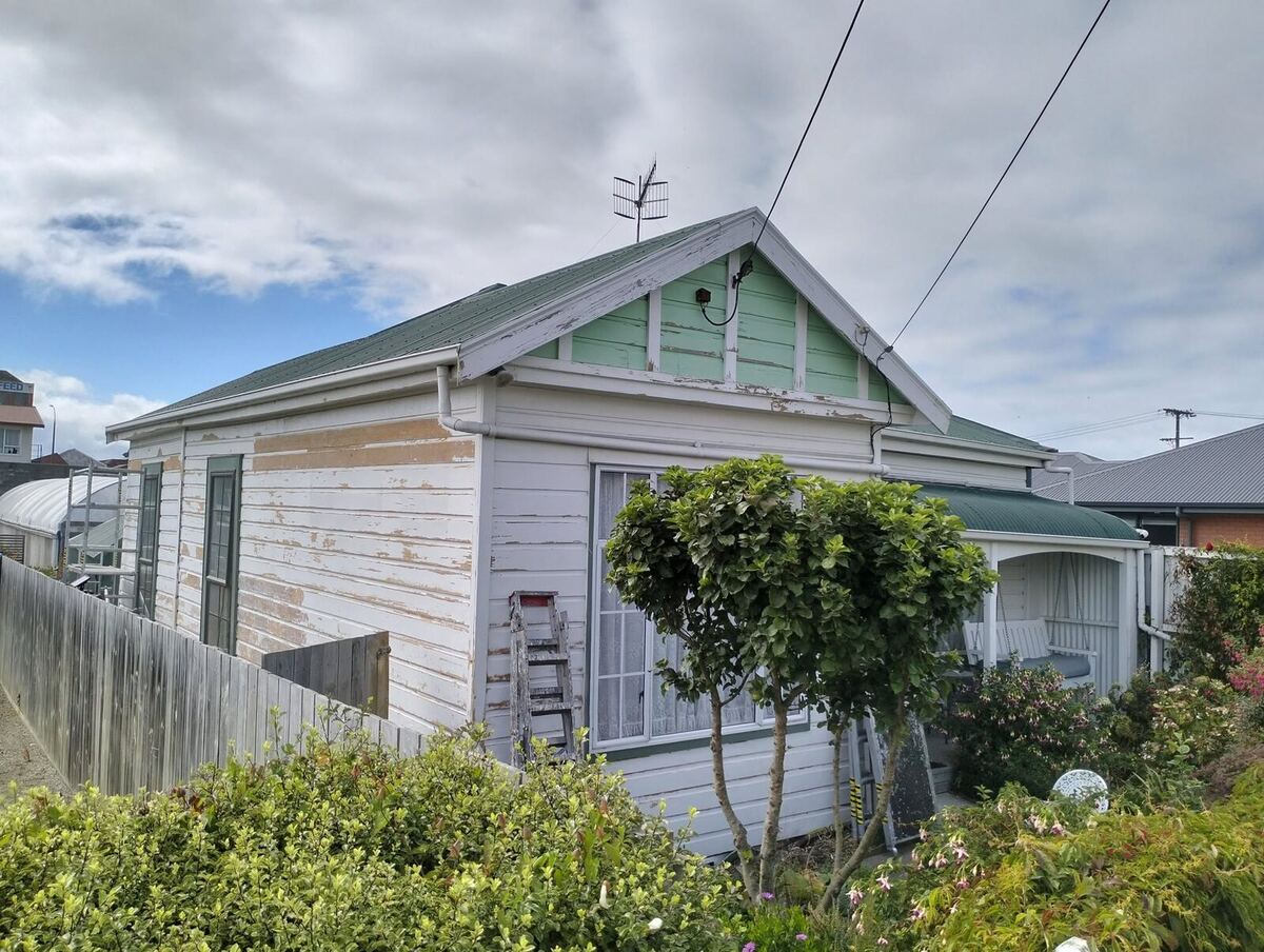 Villa before repaint — peeling weatherboard